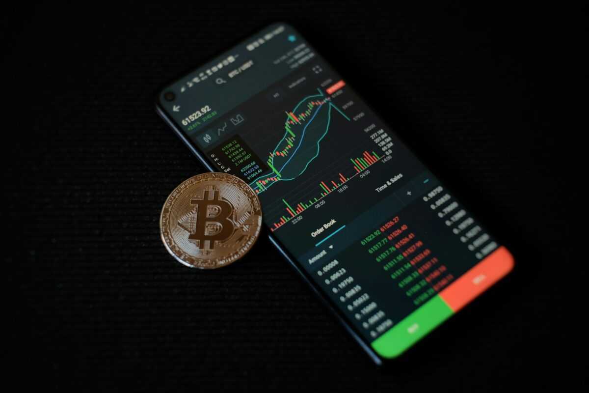 a bitcoin sitting on top of a smart phone