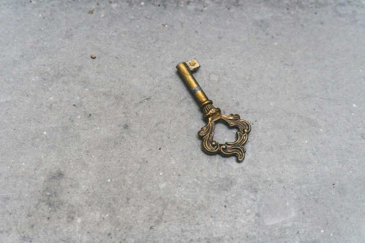 gold skeleton key on gray concrete floor