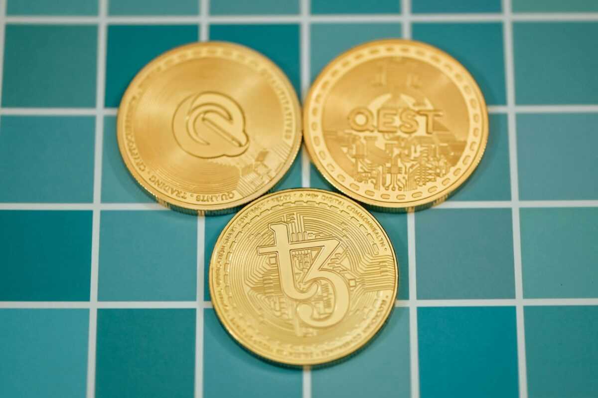 three gold coins sitting on top of a blue tiled floor