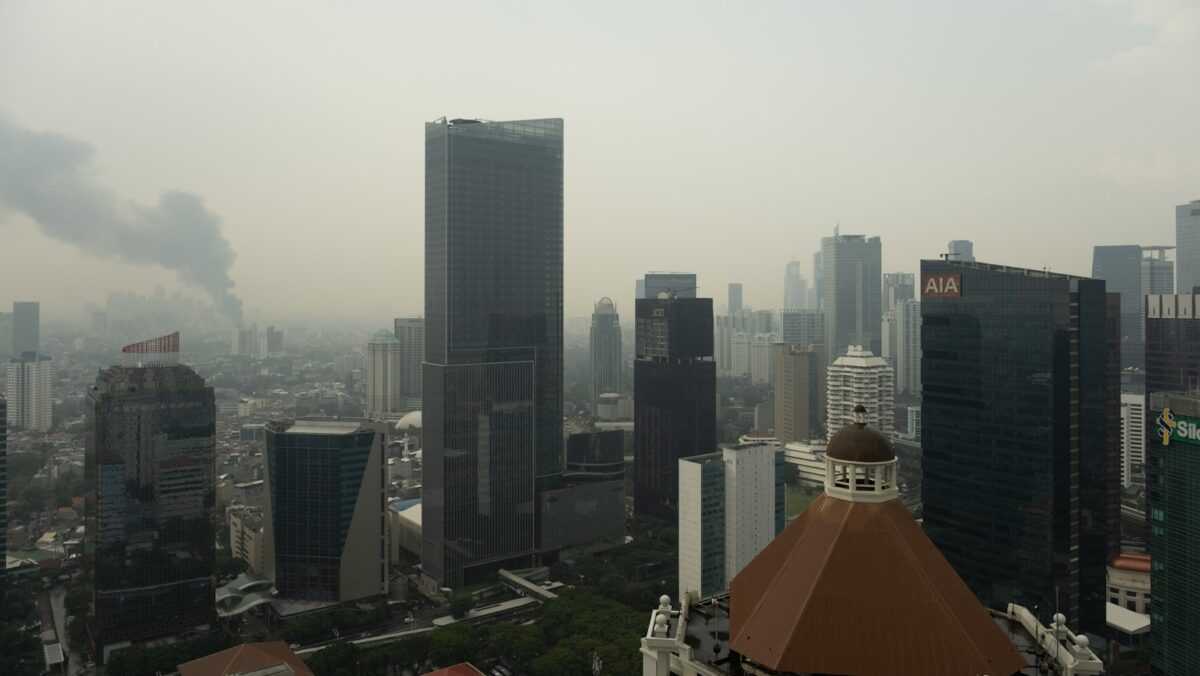 Skyscrapers in a hazy city with smoke in distance